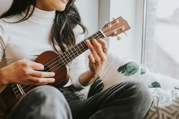 girl playing ukulele while singing