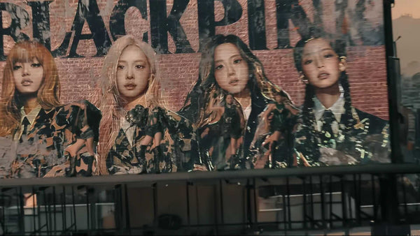 BlackPink members in front of their billboard.