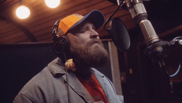 Teddy Swims singing in front of a recording microphone.